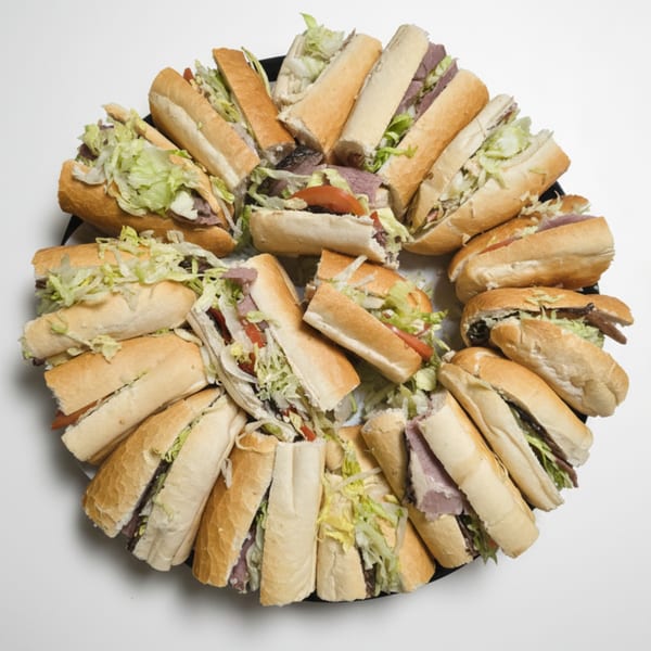 A platter of various submarine sandwiches, cut in half, arranged in a circular pattern.